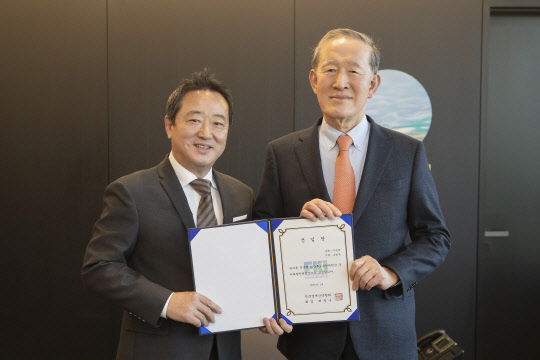 이웅열(왼쪽) 코오롱 명예회장이 30일 서울 여의도 전경련회장에서 허창수 전국경제인연합회 회장으로부터 회장후보추천위원장 겸 미래발전위원장 선임장을 받은 뒤 기념사진을 찍고 있다. 전경련 제공